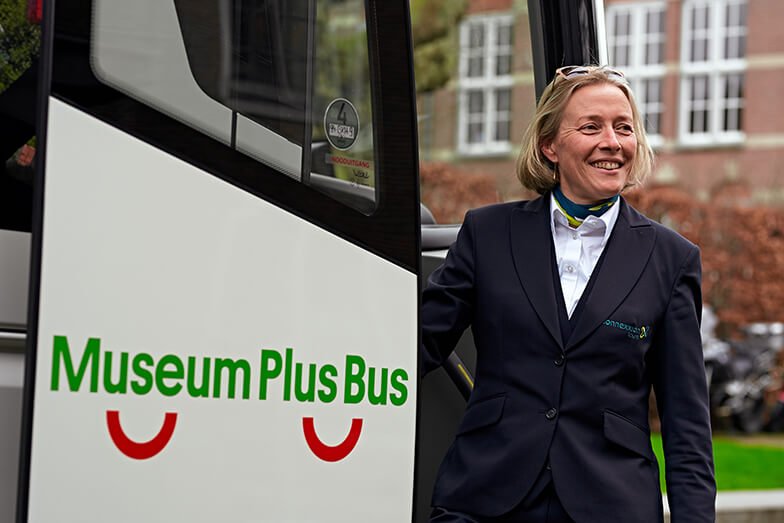 Portret van buschauffeur naast bus