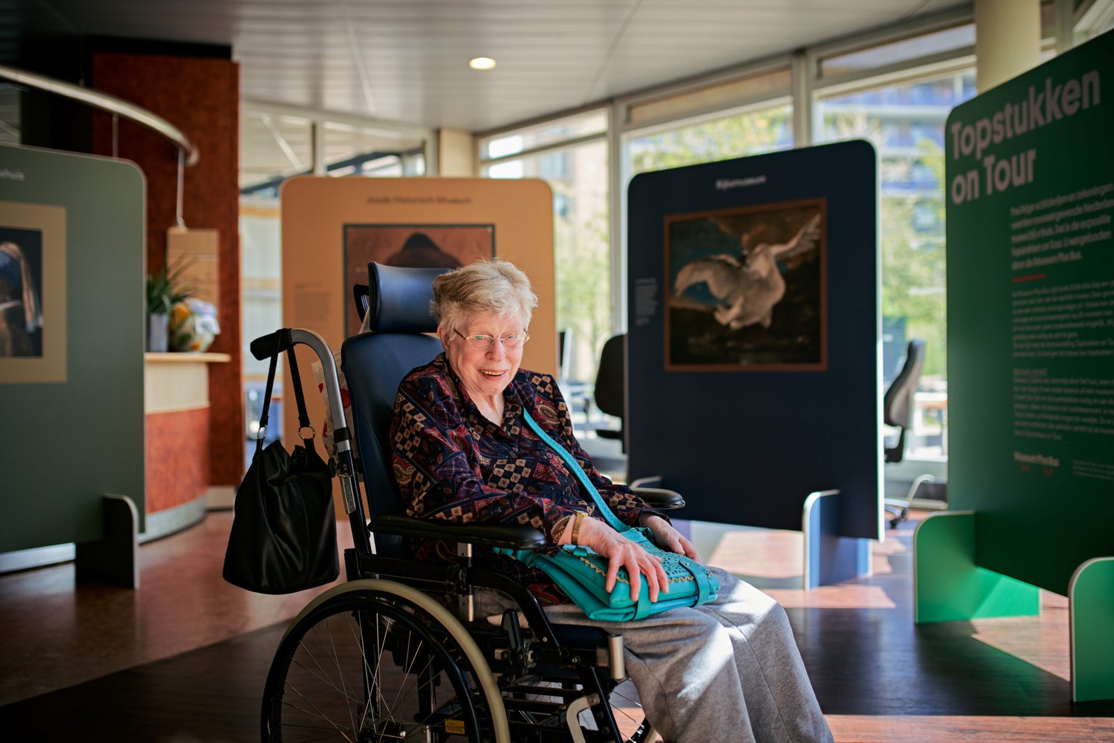 Vrouw in rolstoel omringd door kunst Vrouw in rolstoel omringd door kunst